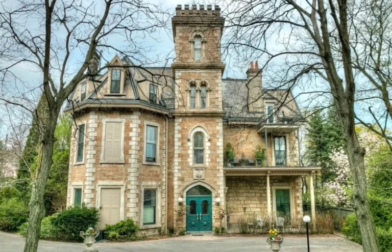 The historic Ballinahinch estate at 316 James Street South in Hamilton, Ontario, showcasing its 1850s stone architecture with a teal Gothic doorway, ornate marble mantle, and a private patio. This vintage condominium complex, renowned for its grand 12-foot ceilings and hardwood floors, captures the essence of Hamilton's architectural heritage.