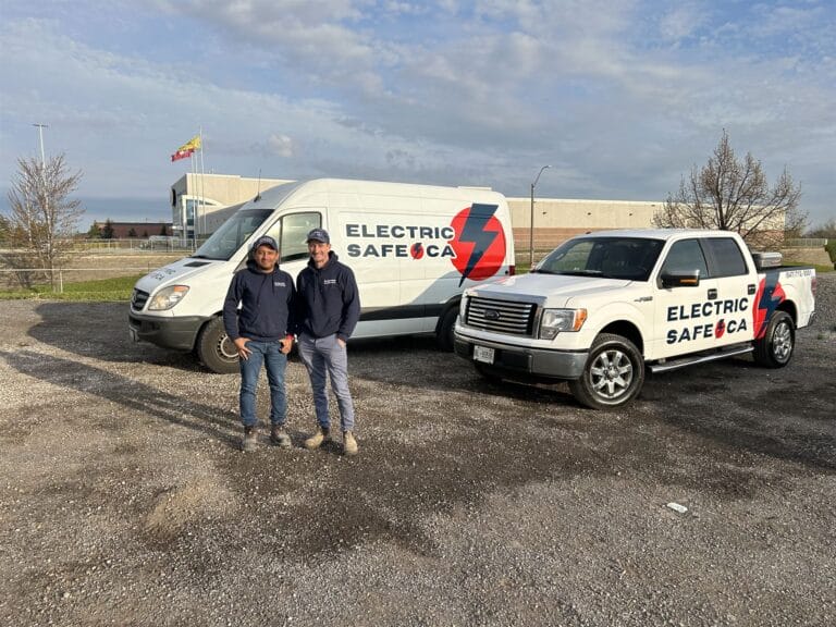 The ElectricSafe team, Hamilton electricians, standing proudly in front of their branded vehicle fleet, showcasing their readiness to provide top-notch electrical services.