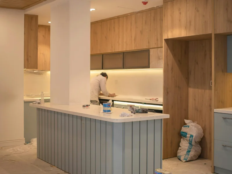 An Ancaster electrician installs under-cabinet lighting in a kitchen for a home renovation project.