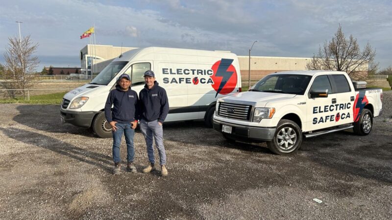 The ElectricSafe team, Hamilton electricians, standing proudly in front of their branded vehicle fleet, showcasing their readiness to provide top-notch electrical services.